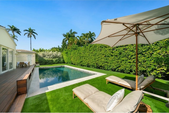 view of swimming pool featuring a wooden deck and a yard