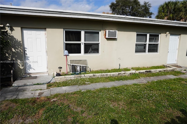 view of side of home featuring a lawn and a wall mounted air conditioner