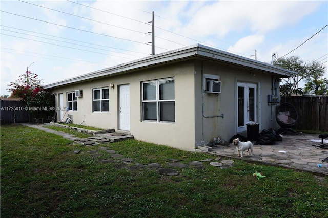 back of property featuring a lawn, french doors, and a patio