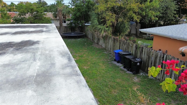 view of yard with a trampoline and a storage shed