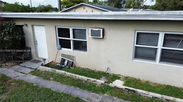 view of property exterior with a wall mounted air conditioner