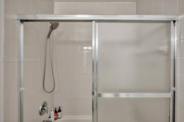 bathroom with bath / shower combo with glass door