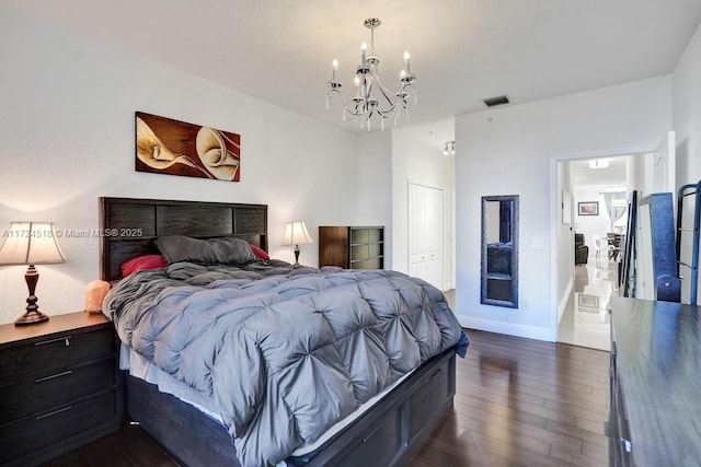 bedroom featuring dark wood-type flooring, a closet, and a notable chandelier