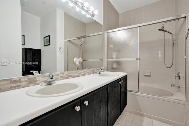 bathroom featuring tile patterned flooring, enclosed tub / shower combo, backsplash, and vanity