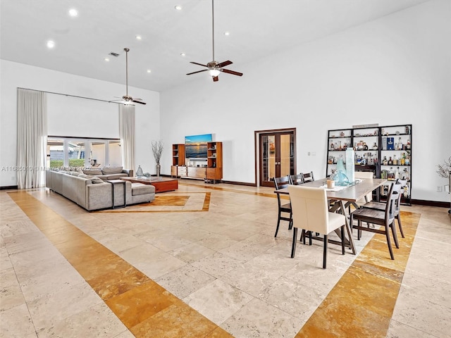 dining room with a high ceiling and ceiling fan