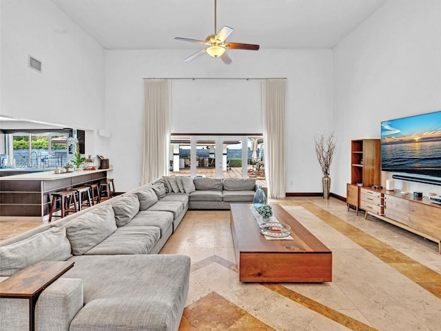 living room featuring a high ceiling, french doors, and ceiling fan