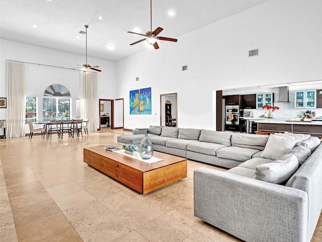 living room featuring a high ceiling and ceiling fan