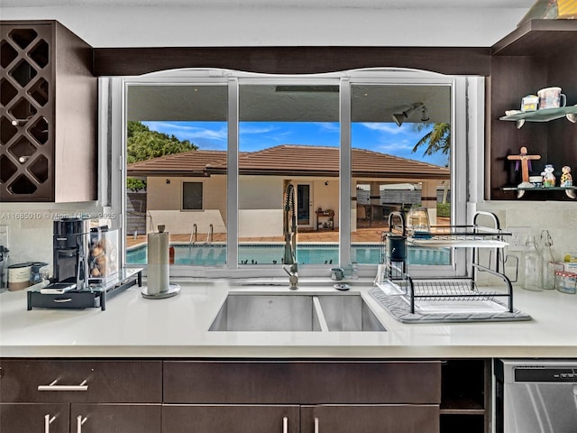 kitchen featuring sink, dark brown cabinets, dishwasher, and decorative backsplash