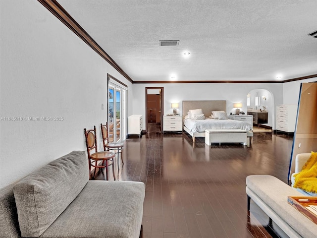 bedroom featuring a textured ceiling, crown molding, and dark hardwood / wood-style floors