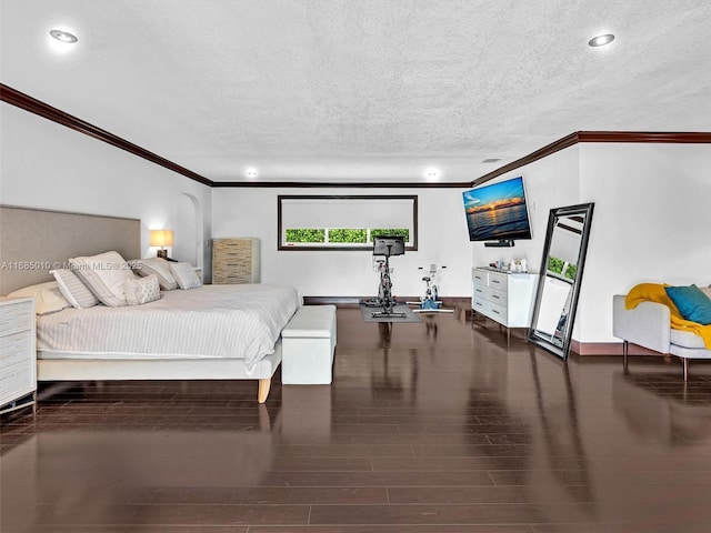 bedroom with a textured ceiling, dark wood-type flooring, and crown molding