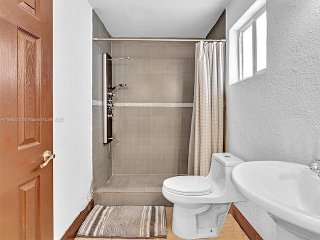 bathroom with sink, a shower with shower curtain, a textured ceiling, and toilet