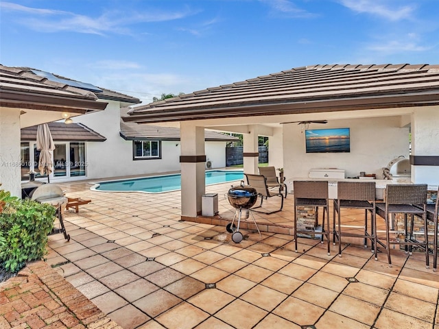 view of pool featuring a bar and a patio