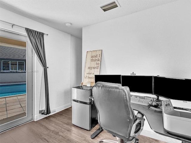 office area with hardwood / wood-style flooring and a textured ceiling