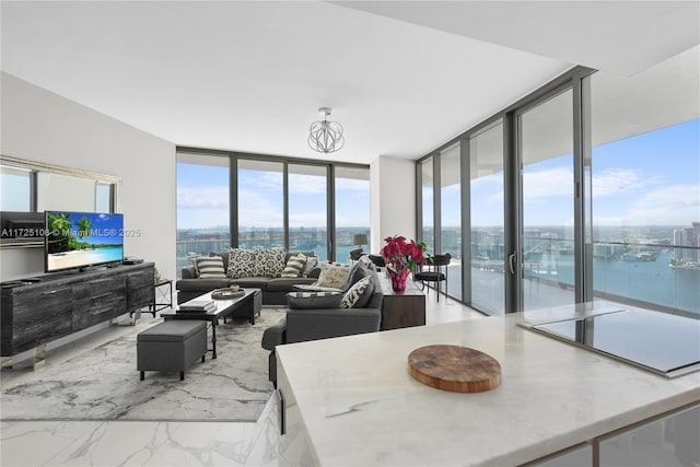 living area with a water view, marble finish floor, floor to ceiling windows, and a city view