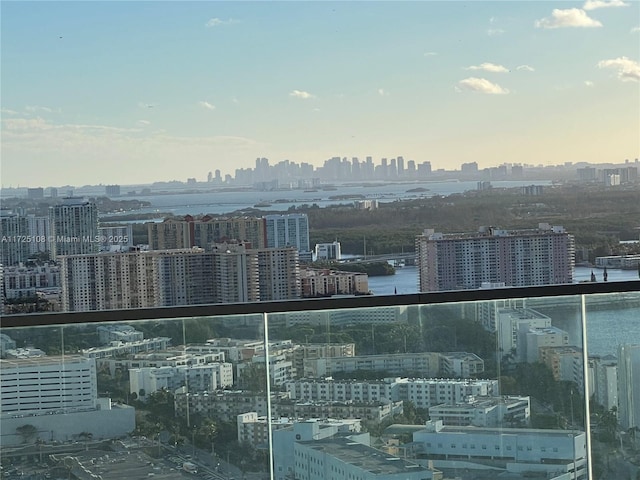 balcony at dusk featuring a water view