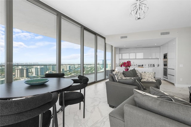 living area with marble finish floor, expansive windows, visible vents, and an inviting chandelier