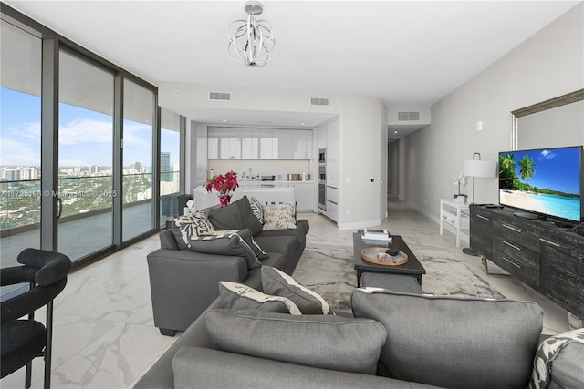 living room featuring marble finish floor, visible vents, and a city view