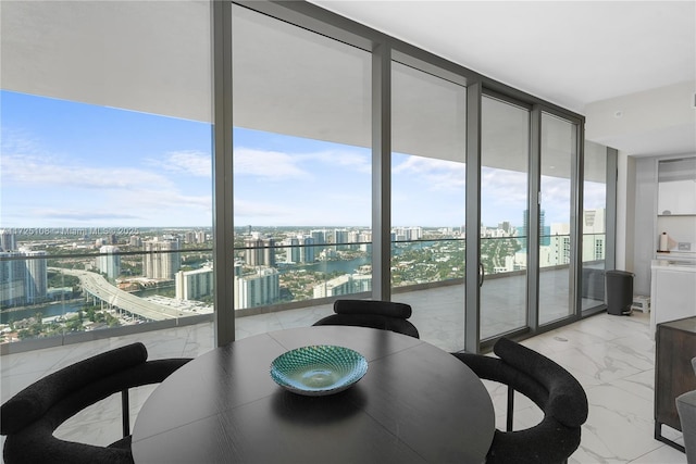 dining space featuring expansive windows, marble finish floor, a view of city, and a healthy amount of sunlight