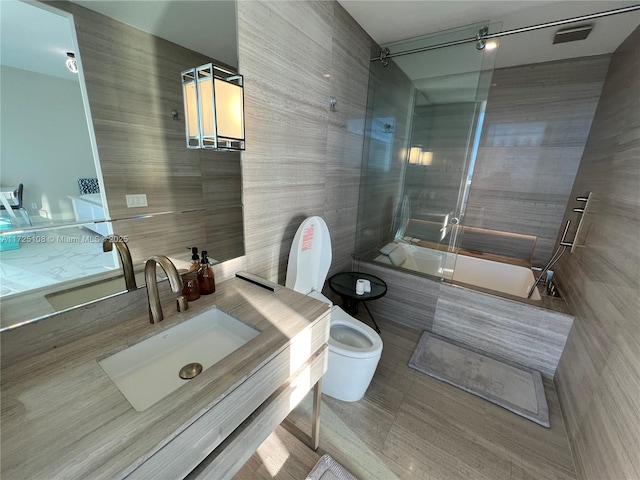 full bathroom with vanity, tiled shower / bath combo, and toilet