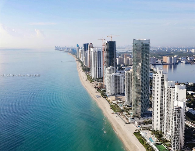 birds eye view of property with a view of the beach, a city view, and a water view