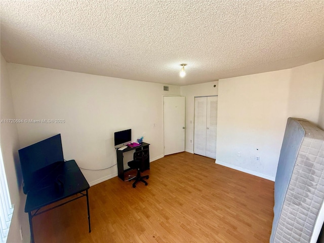 office area with hardwood / wood-style floors and a textured ceiling