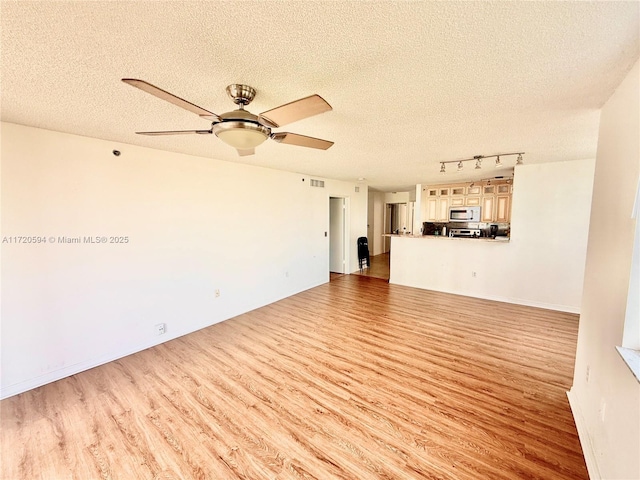 unfurnished living room featuring light hardwood / wood-style floors, a textured ceiling, and ceiling fan