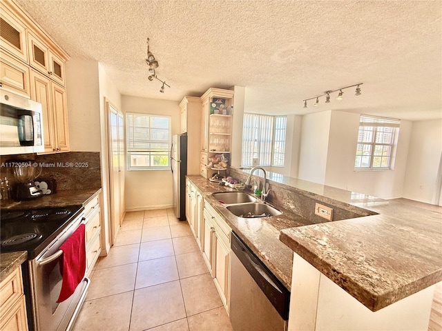 kitchen featuring a wealth of natural light, light tile patterned floors, sink, and stainless steel appliances