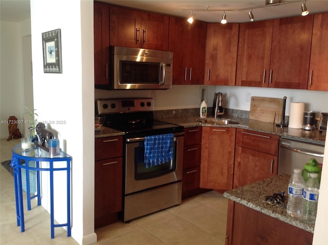 kitchen featuring stainless steel appliances, light tile patterned flooring, sink, and stone counters