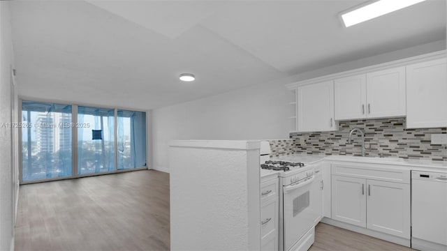 kitchen featuring white appliances, white cabinets, sink, and tasteful backsplash