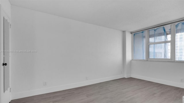 spare room with wood-type flooring