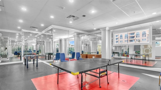 recreation room featuring decorative columns, crown molding, and a paneled ceiling