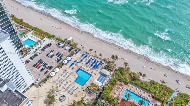 drone / aerial view featuring a water view and a view of the beach