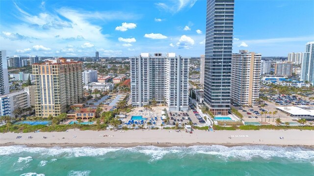 drone / aerial view featuring a beach view and a water view