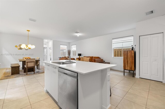 kitchen featuring stainless steel dishwasher, pendant lighting, an island with sink, light tile patterned floors, and sink