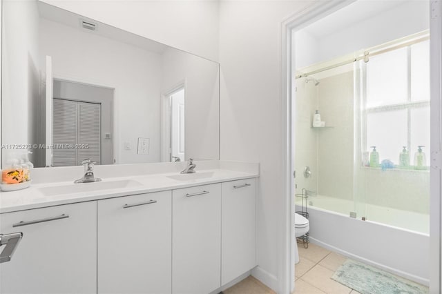 full bathroom featuring toilet, bath / shower combo with glass door, tile patterned flooring, and vanity