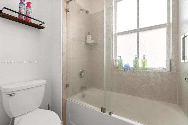 bathroom with toilet, combined bath / shower with glass door, and a wealth of natural light