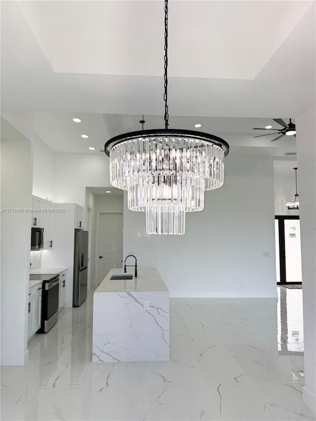 room details with ceiling fan with notable chandelier, appliances with stainless steel finishes, and sink