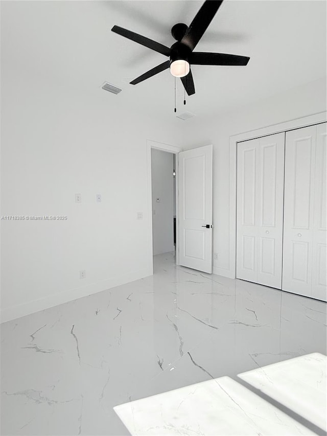 unfurnished bedroom with ceiling fan and a closet