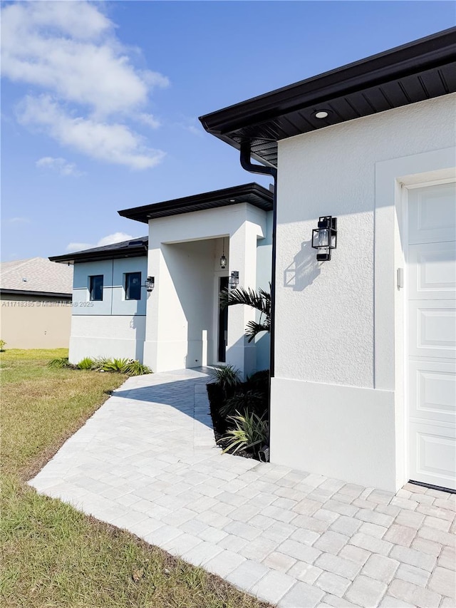 property entrance with a yard and a garage