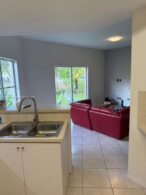 kitchen featuring sink, white cabinets, plenty of natural light, and light tile patterned floors