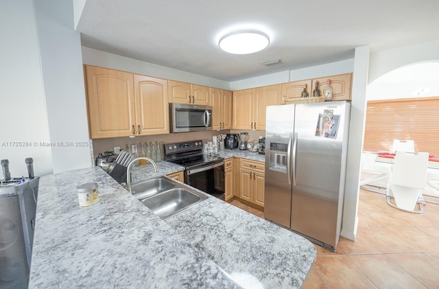 kitchen with kitchen peninsula, appliances with stainless steel finishes, light brown cabinets, and sink