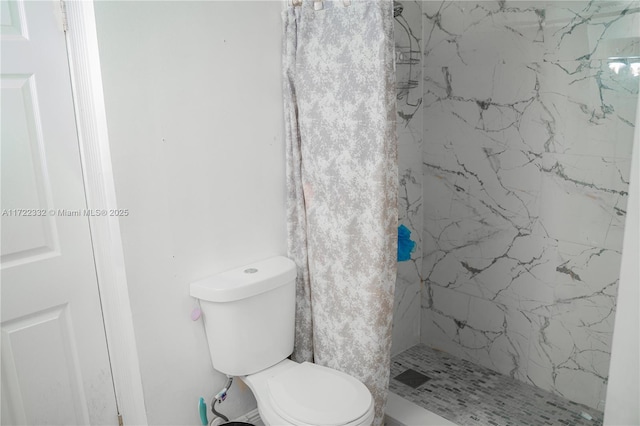 bathroom with toilet and a tile shower