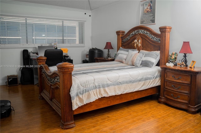 bedroom featuring vaulted ceiling, crown molding, and hardwood / wood-style flooring