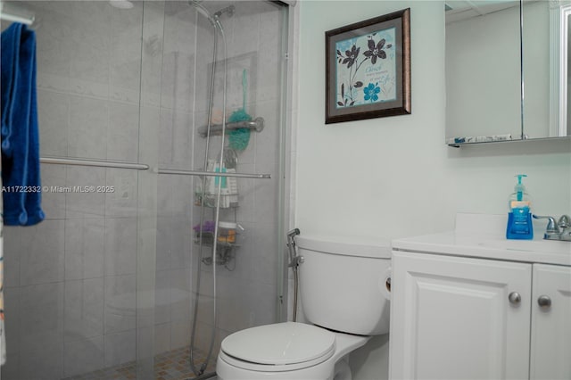 bathroom featuring toilet, a shower with shower door, and vanity