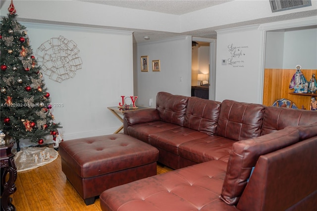 living room featuring crown molding, a textured ceiling, and hardwood / wood-style flooring