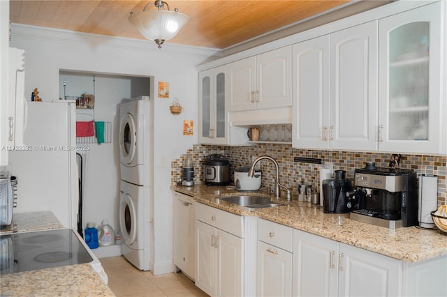 kitchen featuring dishwasher, white cabinetry, stacked washer / drying machine, sink, and wooden ceiling