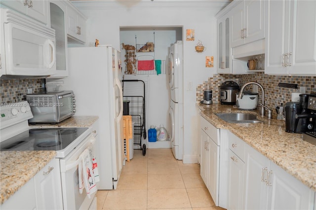 kitchen with light tile patterned floors, white cabinetry, backsplash, white appliances, and sink