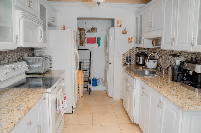 kitchen with light tile patterned floors, tasteful backsplash, white appliances, white cabinets, and sink