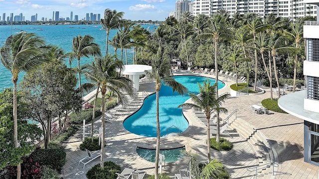 view of swimming pool featuring a water view and a patio