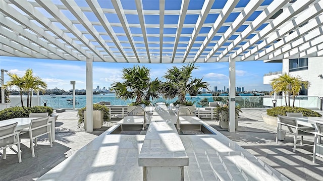 view of patio featuring a pergola and a water view